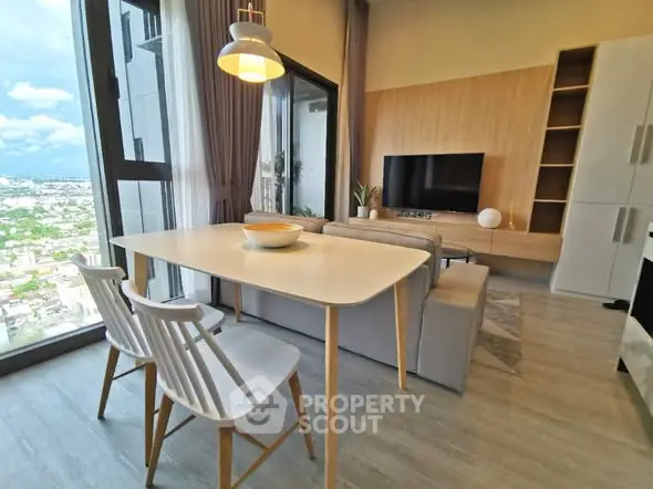 Modern living room with large windows and city view, featuring stylish furniture and open layout.