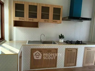 Modern kitchen with sleek cabinetry and gas stove, featuring a stylish backsplash and ample natural light.