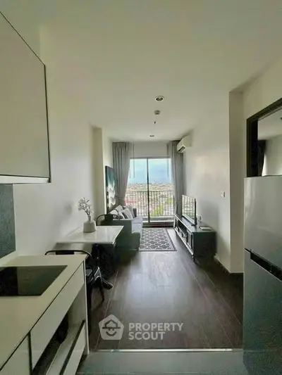 Modern living room with balcony and city view, sleek furniture and natural light.