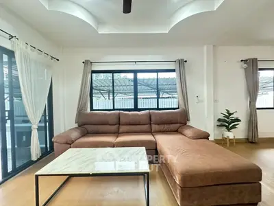 Spacious living room with modern sectional sofa and large windows