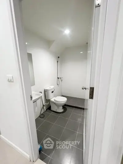 Modern minimalist bathroom with sleek fixtures and tiled flooring