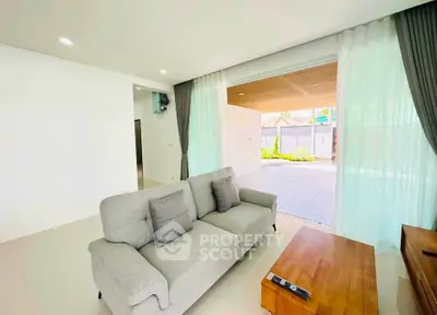 Spacious living room with modern decor and large sliding doors opening to a patio.