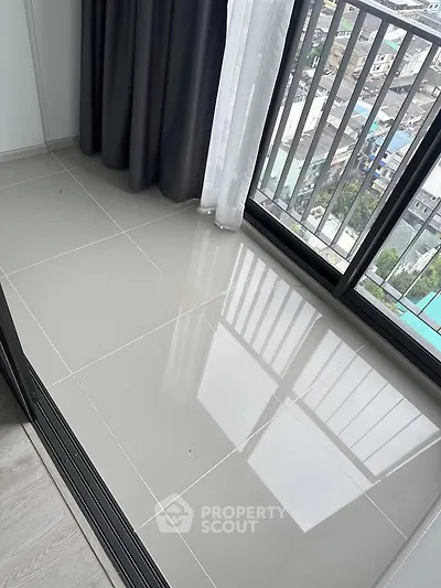 Modern apartment balcony with city view and sleek tiled flooring.