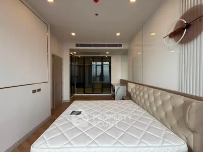 Modern bedroom with stylish decor and large window offering city view
