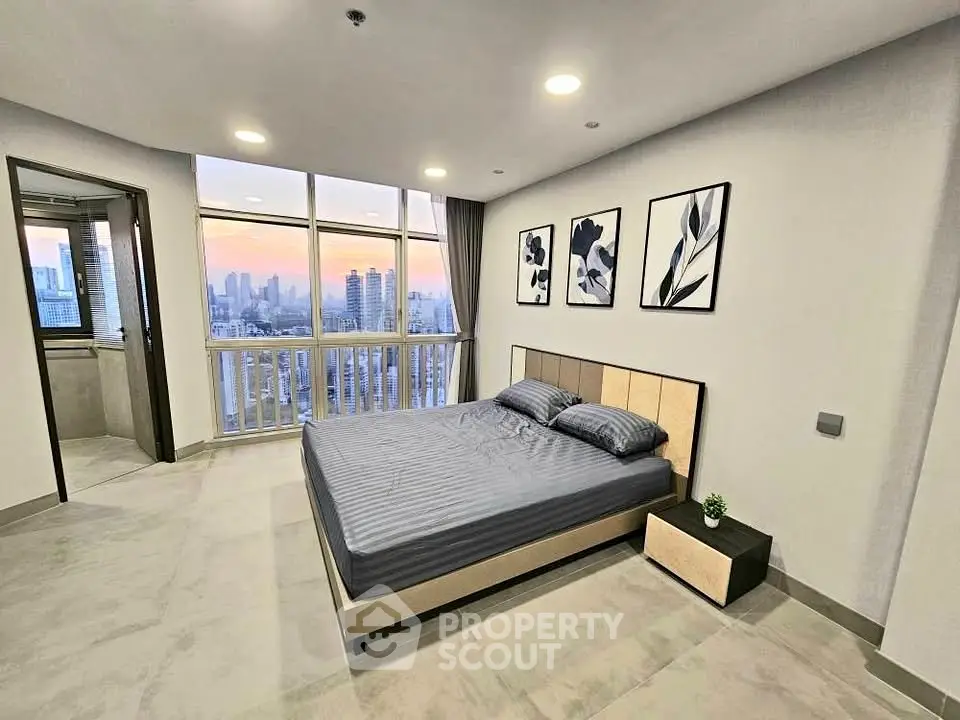 Spacious bedroom with stunning city view and modern decor in high-rise apartment.