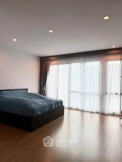 Spacious bedroom with large windows and modern decor