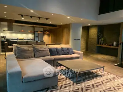 Luxurious modern living room with spacious seating and stylish kitchen in open layout design.