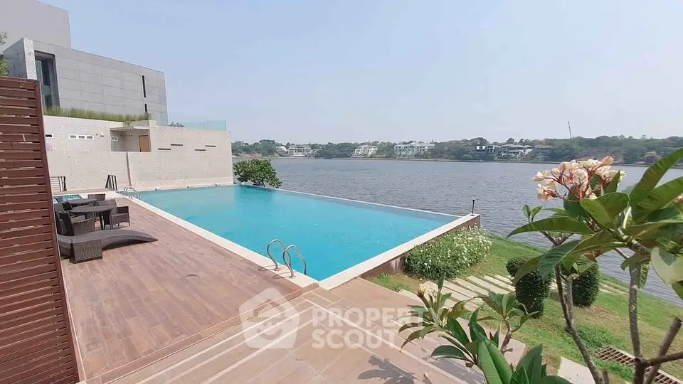 Luxurious infinity pool with stunning waterfront view and modern architecture.