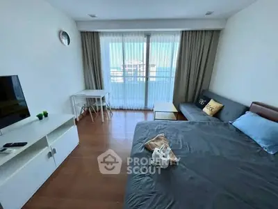 Modern bedroom with balcony view, featuring sleek furniture and natural light.