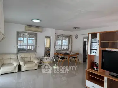 Spacious living room with modern furniture and natural light, perfect for family gatherings.