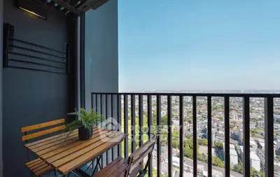 Stunning high-rise balcony with panoramic city views and cozy seating area.