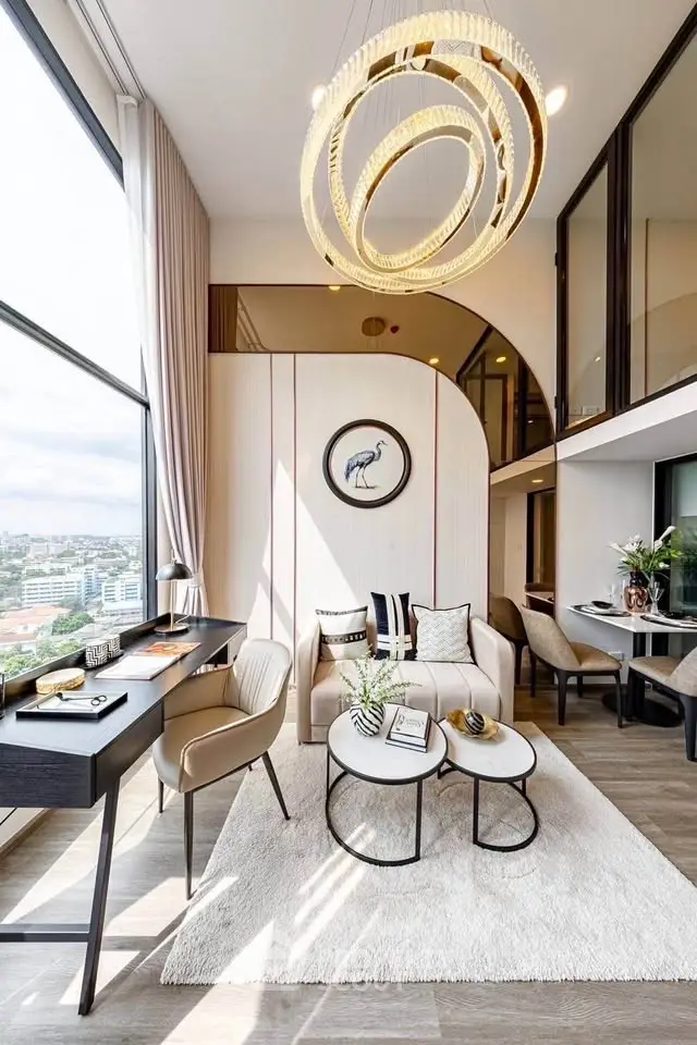 Luxurious modern living room with high ceilings, elegant chandelier, and stunning city view.