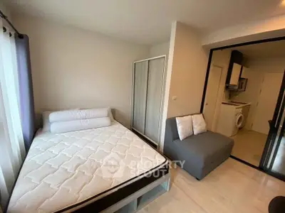 Modern bedroom with cozy bed and adjacent kitchenette in stylish apartment.