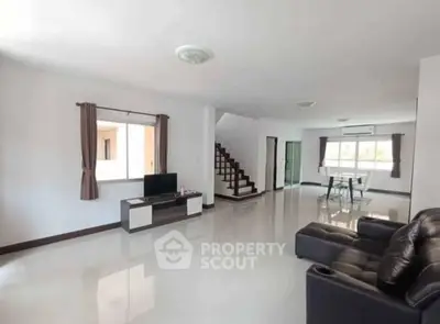 Spacious modern living room with sleek furniture and natural light, perfect for family gatherings.