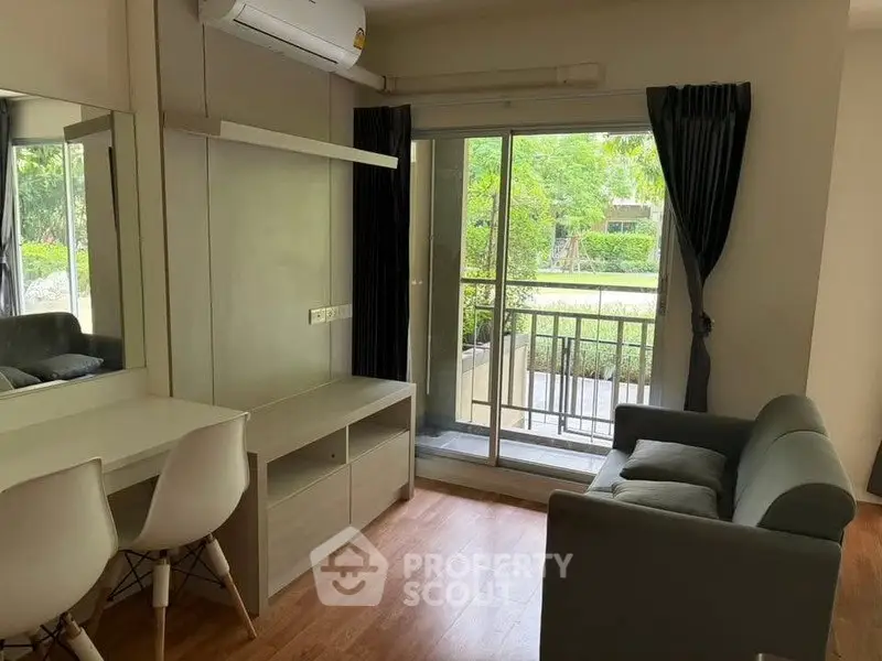 Modern living room with balcony view, featuring sleek furniture and natural light.