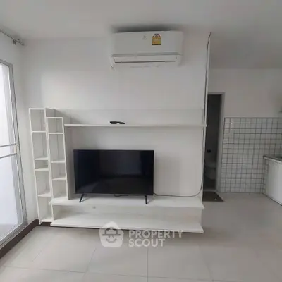 Modern living room with sleek TV stand and air conditioning in a bright apartment.