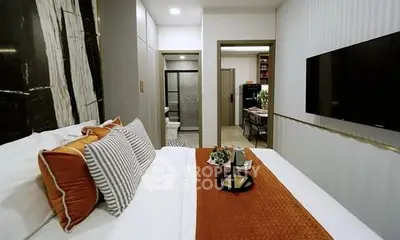 Modern bedroom with stylish decor and wall-mounted TV