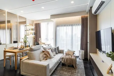 Modern living room with stylish decor, large windows, and cozy seating area in a contemporary apartment.