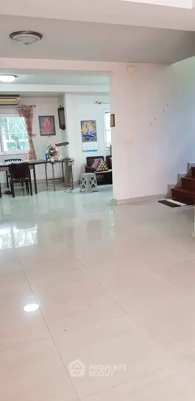 Spacious open-plan living area with modern decor and staircase