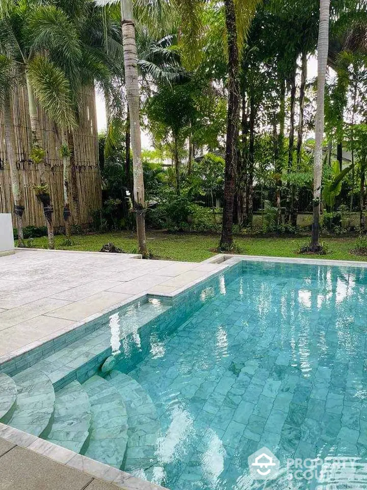 Luxurious backyard pool with lush tropical garden setting