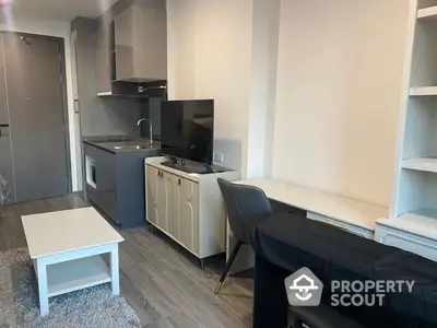 Modern studio apartment with integrated living space featuring a sleek kitchenette, cozy dining area, and ample shelving, perfect for urban living.