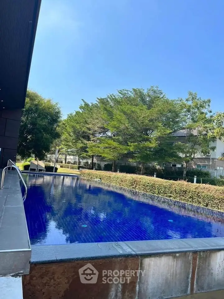 Luxurious outdoor pool with serene garden view, perfect for relaxation and leisure in upscale property.