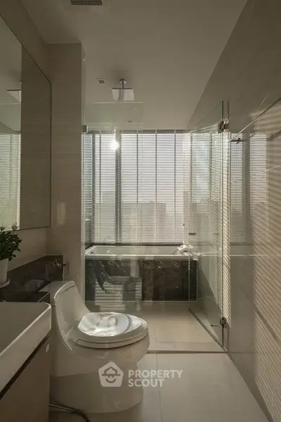 Luxurious modern bathroom with glass shower and city view, featuring sleek fixtures and elegant design.