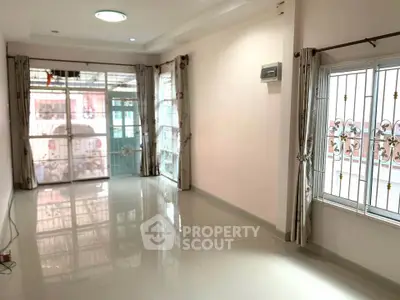 Spacious living room with large windows and natural light, perfect for modern living.