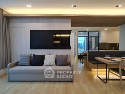 Modern living room with sleek design and open kitchen layout, featuring stylish furniture and ambient lighting.