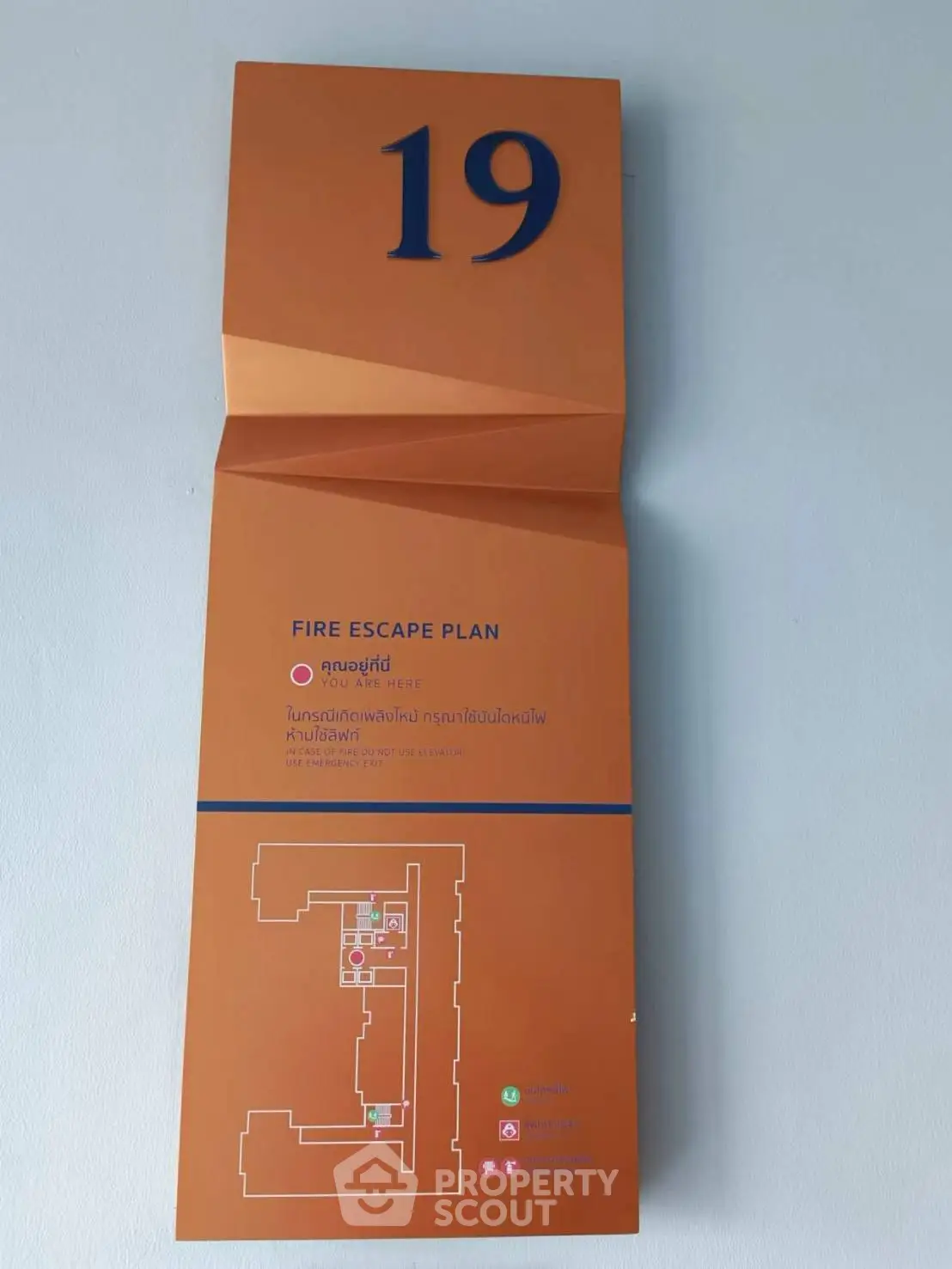 Fire escape plan on wall with floor layout and emergency instructions.