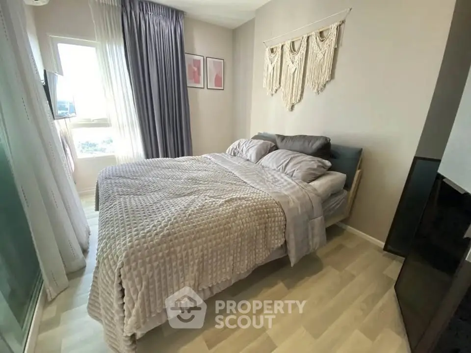 Cozy bedroom with stylish decor and natural light, perfect for relaxation.