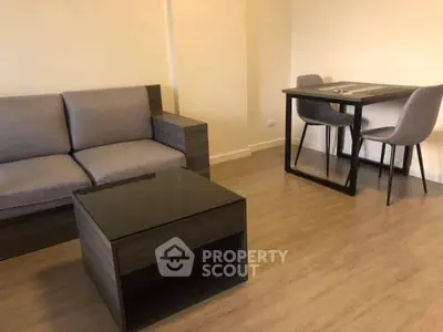 Modern living room with sleek furniture and wooden flooring, perfect for cozy gatherings.