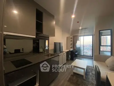 Modern open-plan living space with sleek kitchen, comfortable seating area, and large windows offering an abundance of natural light and city views.