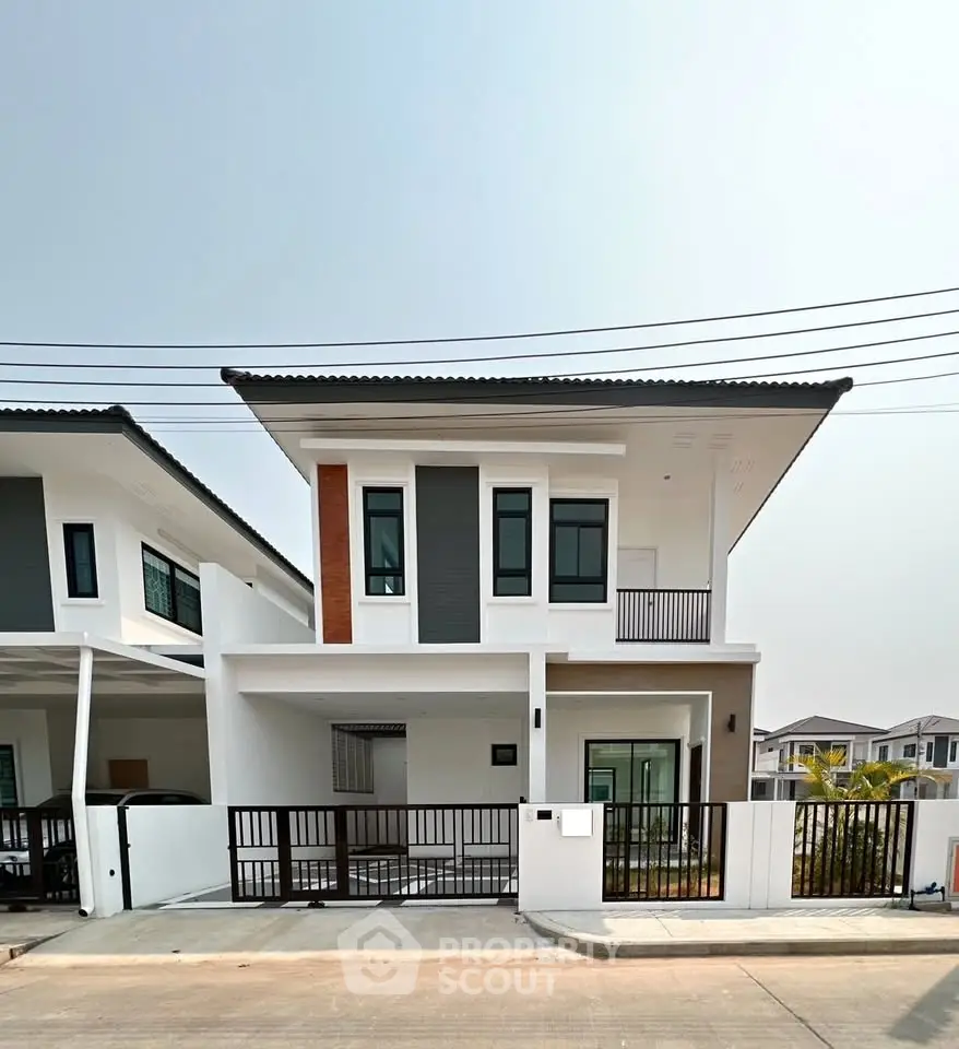 Modern two-story house with sleek design and spacious driveway in a suburban neighborhood.