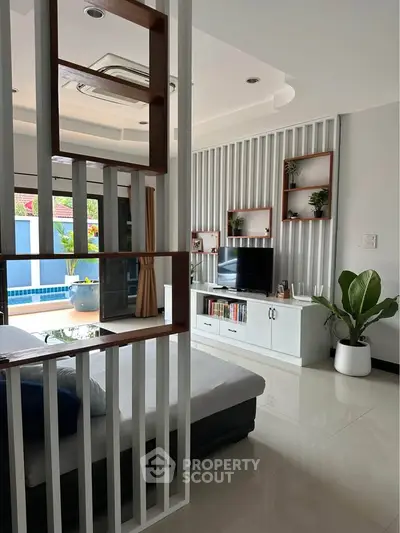 Modern living room with stylish decor and pool view, featuring sleek furniture and natural light.