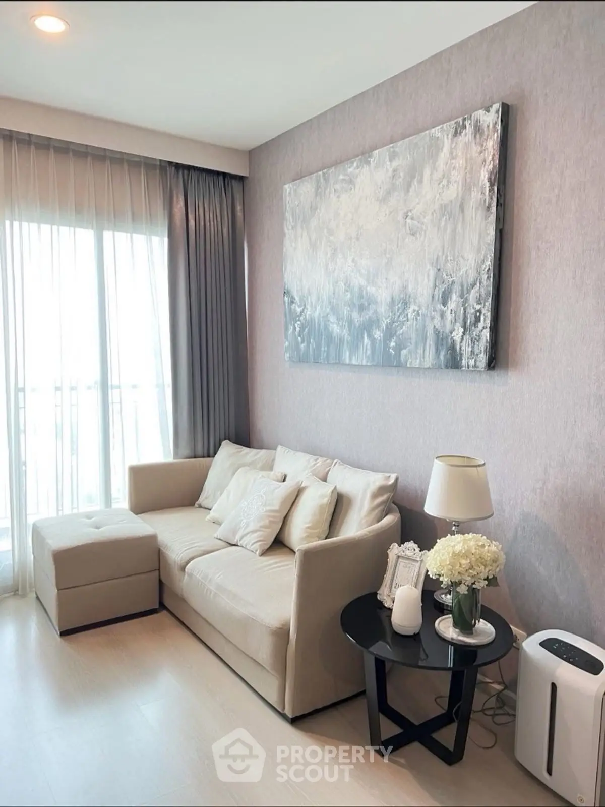 Elegant living room with modern decor, cozy sofa, and large window for natural light.