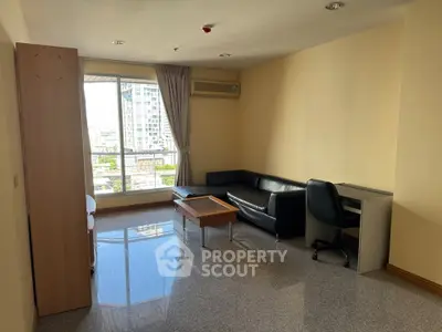 Spacious living room with city view, modern furniture, and ample natural light.
