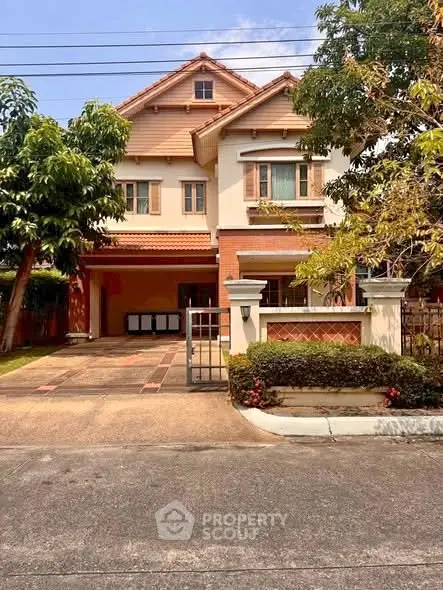 Charming two-story house with a spacious driveway and lush greenery, perfect for family living.