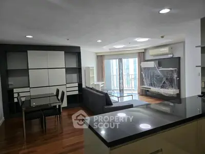 Modern living room with open layout, sleek furniture, and large windows offering city views.