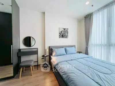 Modern bedroom with stylish decor and natural light, featuring a cozy bed and elegant furnishings.