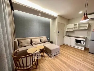 Modern living room with cozy sofa and open kitchen layout, perfect for urban living.