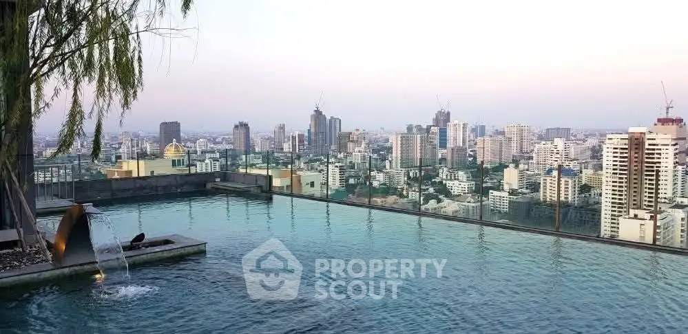 Stunning rooftop pool with panoramic city skyline views at sunset.