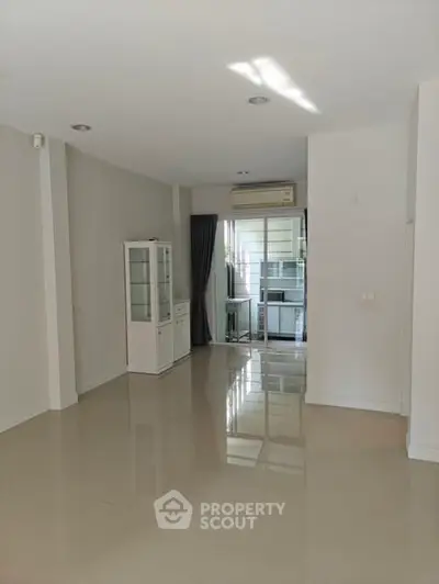 Spacious modern living area with glossy floors and natural light