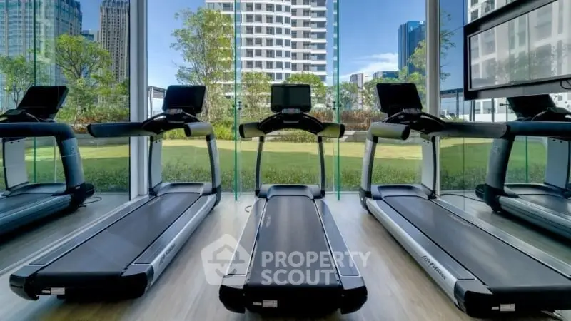Modern gym with treadmills and city view, ideal for fitness enthusiasts.