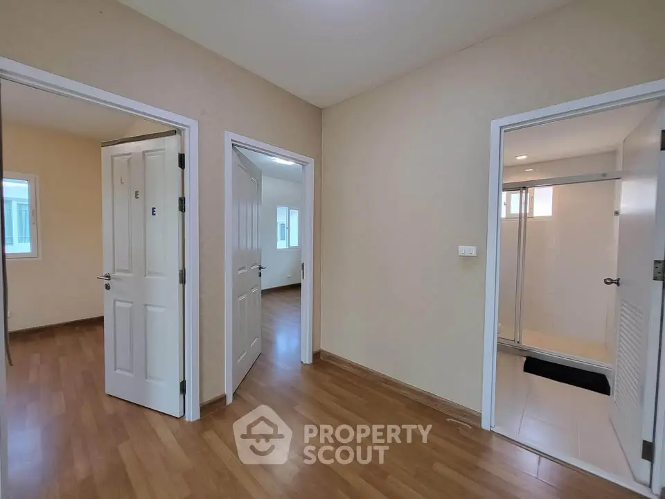 Spacious interior with wooden flooring and multiple rooms, ideal for modern living.