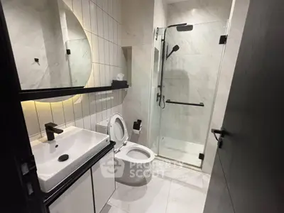 Modern bathroom with sleek fixtures and glass shower enclosure.