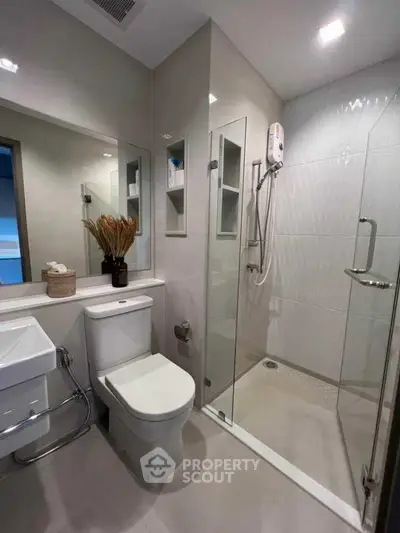 Modern bathroom with glass shower and sleek fixtures in a contemporary home.