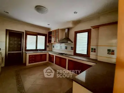 Spacious kitchen with modern cabinetry and gas stove in a cozy home setting.