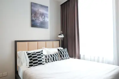 Modern bedroom with stylish decor and large window for natural light.