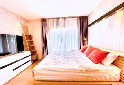Spacious bedroom with modern decor, large window, and cozy lighting for a serene living experience.
